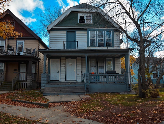 view of property with covered porch and a balcony