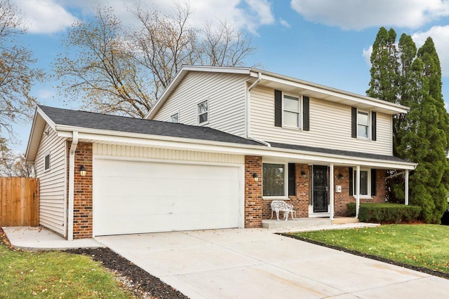 view of front facade featuring a front lawn, covered porch, and a garage