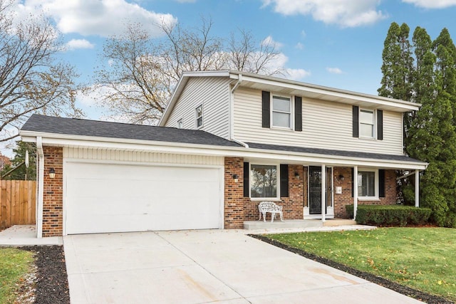 view of property with covered porch, a garage, and a front yard