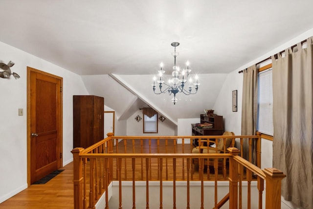 interior space with wood-type flooring, lofted ceiling, and a notable chandelier