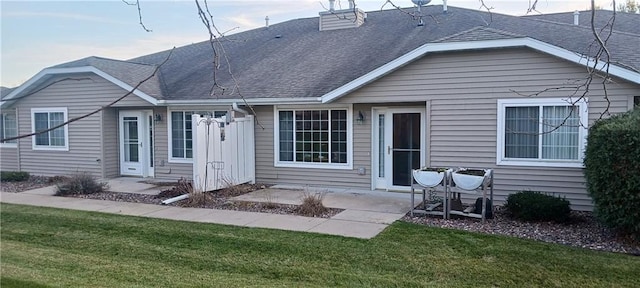 back of house with a yard and a patio