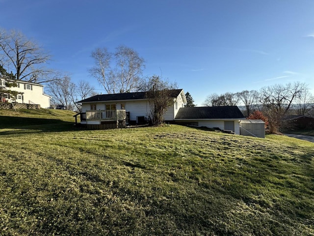 rear view of property featuring a deck and a yard