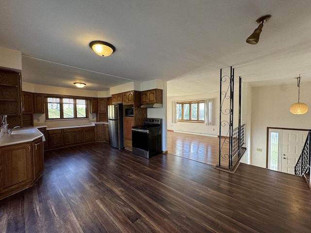 kitchen with dark hardwood / wood-style flooring, stainless steel appliances, hanging light fixtures, and sink