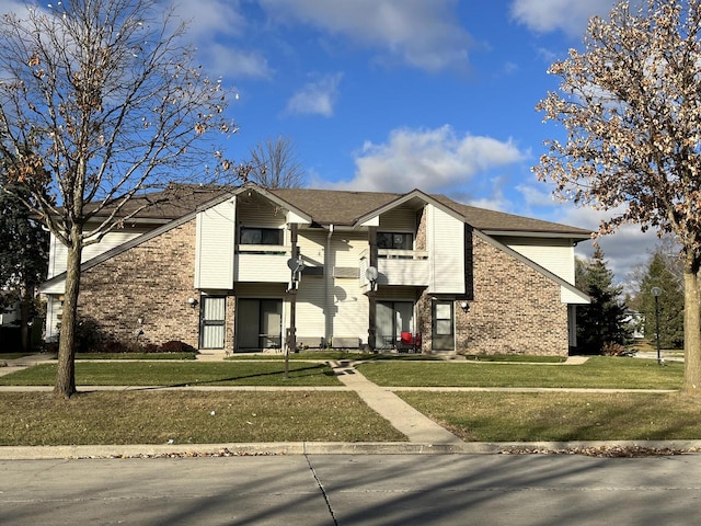 view of front facade featuring a front yard and a balcony