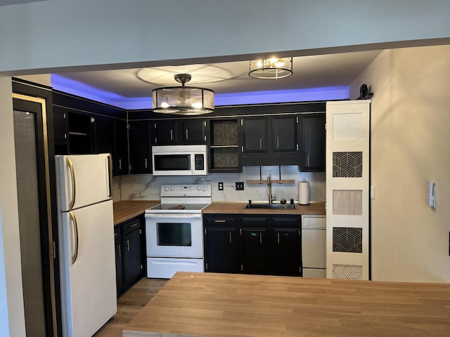 kitchen featuring sink, wood counters, tasteful backsplash, decorative light fixtures, and white appliances