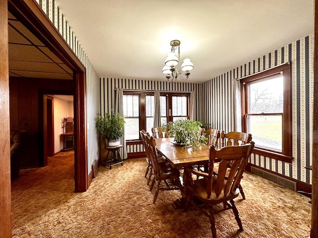 dining area with carpet and a chandelier