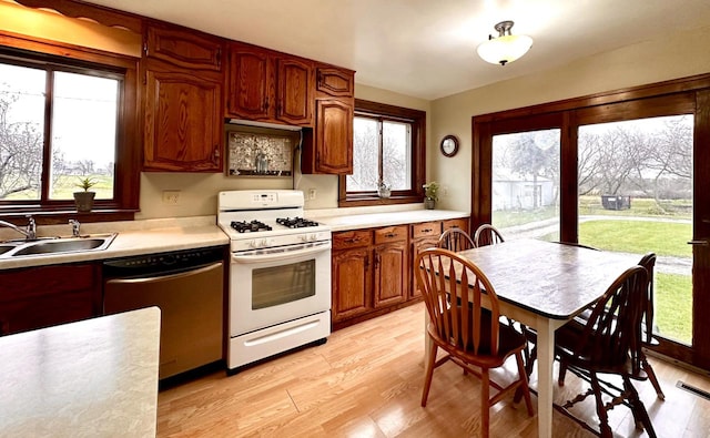 kitchen featuring dishwasher, light hardwood / wood-style flooring, sink, and gas range gas stove