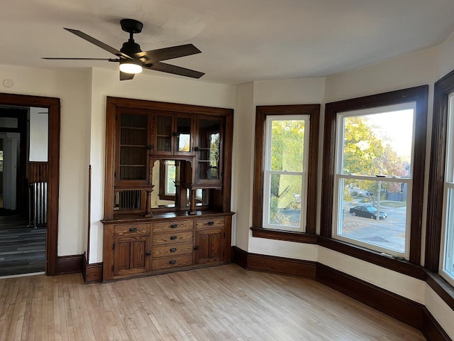 unfurnished dining area featuring ceiling fan and light wood-type flooring