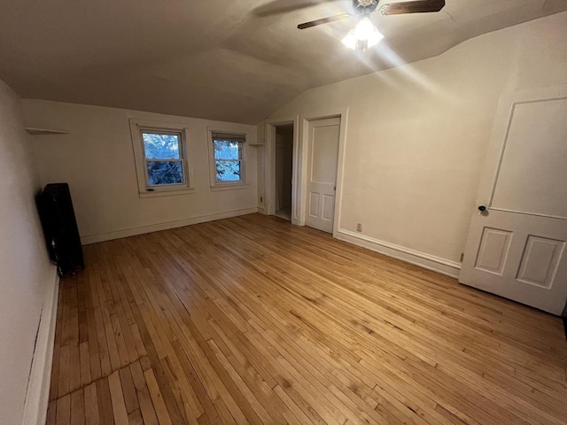 unfurnished bedroom featuring ceiling fan, vaulted ceiling, and light wood-type flooring