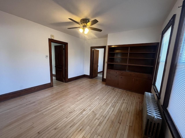 unfurnished bedroom with radiator heating unit, light hardwood / wood-style floors, and ceiling fan