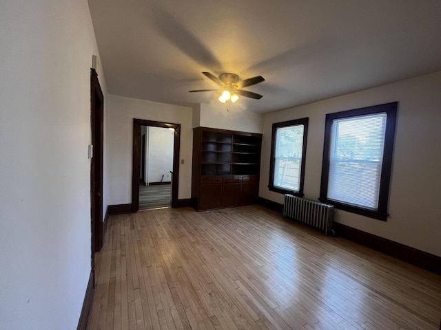 interior space with radiator heating unit, light wood-type flooring, and ceiling fan