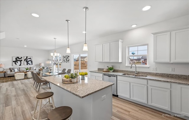 kitchen featuring white cabinets, dishwasher, sink, and light hardwood / wood-style flooring