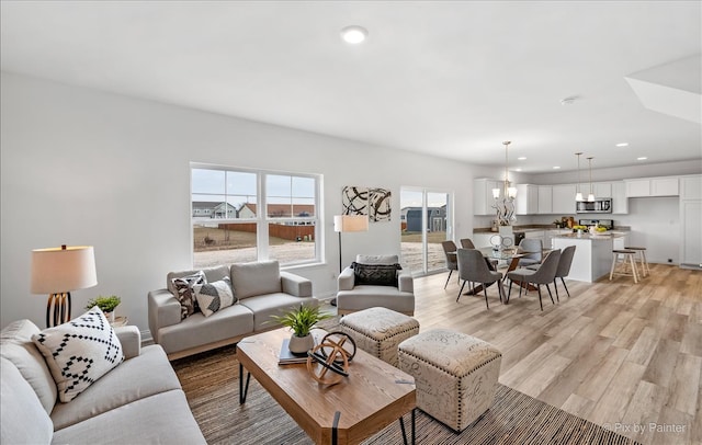 living room featuring a chandelier and light hardwood / wood-style flooring