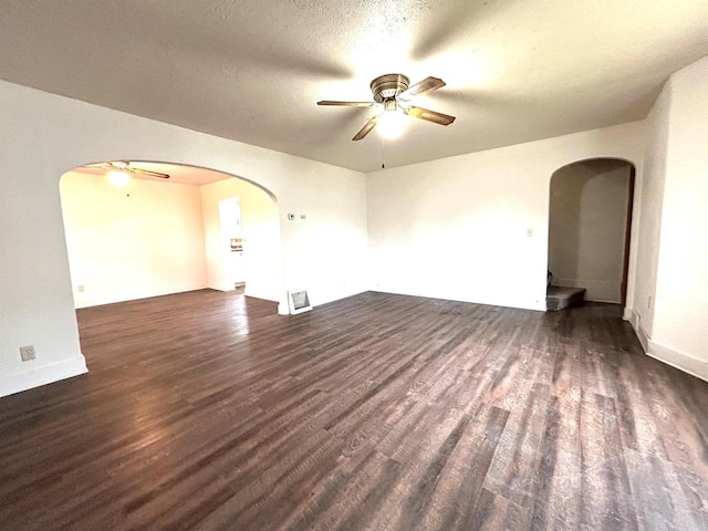 spare room featuring a textured ceiling, ceiling fan, and dark wood-type flooring