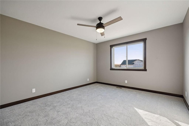 spare room with ceiling fan and light colored carpet