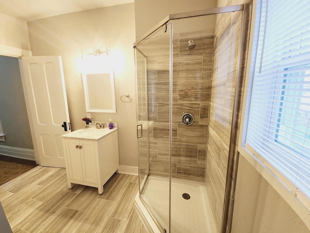 bathroom featuring vanity, a healthy amount of sunlight, and walk in shower