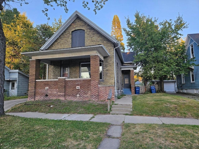 bungalow with an outbuilding and a front lawn