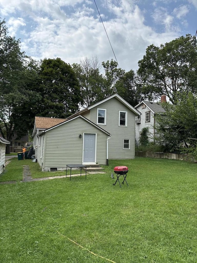 rear view of property featuring a lawn