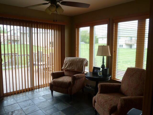 living area with ceiling fan and a healthy amount of sunlight