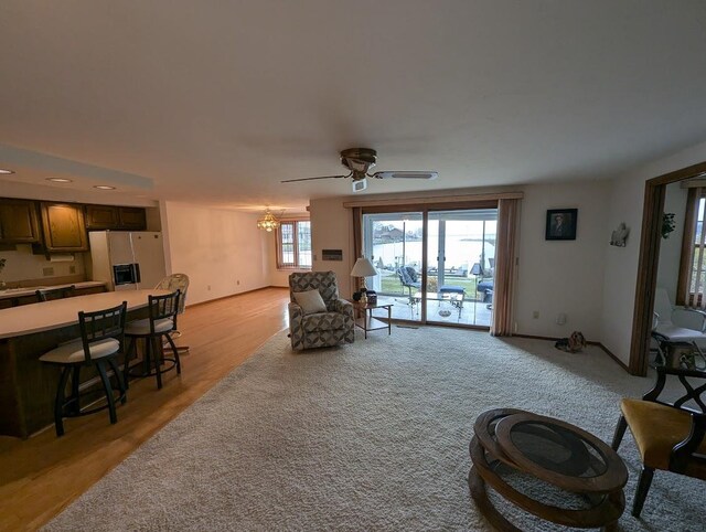 living room featuring light hardwood / wood-style flooring and ceiling fan