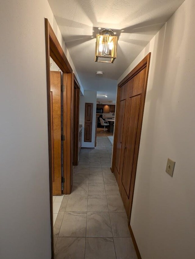 hall featuring a textured ceiling