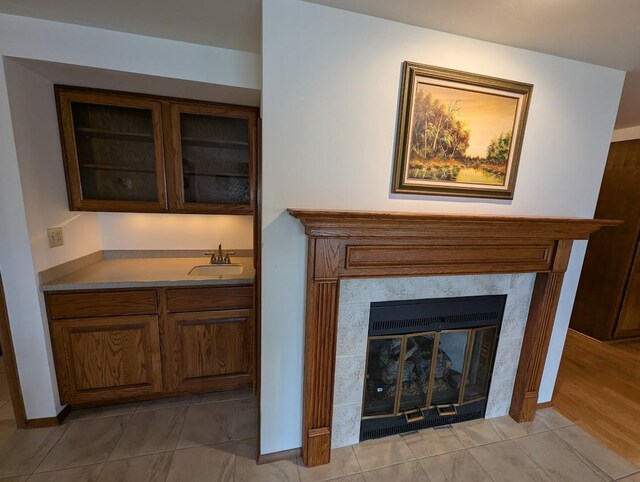 interior space with light hardwood / wood-style floors, sink, and a tile fireplace