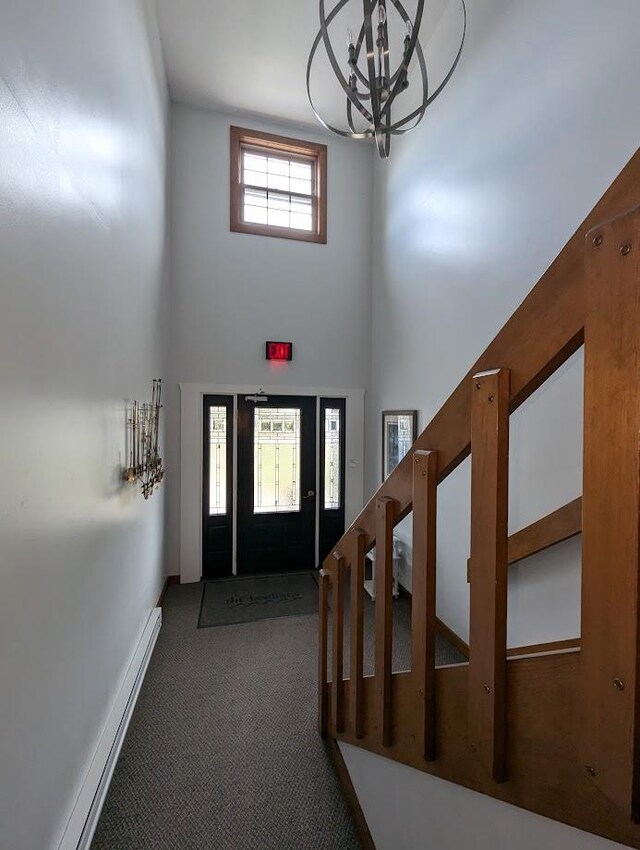 carpeted foyer featuring a towering ceiling