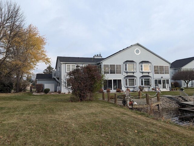 rear view of property featuring a sunroom and a yard