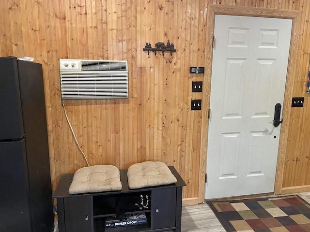 interior space featuring hardwood / wood-style floors, a wall mounted AC, and wooden walls