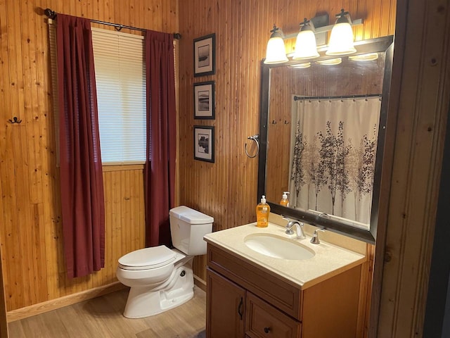 bathroom featuring vanity, hardwood / wood-style flooring, toilet, and wooden walls