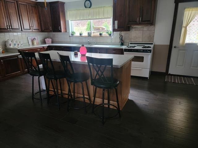 kitchen with a breakfast bar, a center island, a wealth of natural light, and gas range gas stove