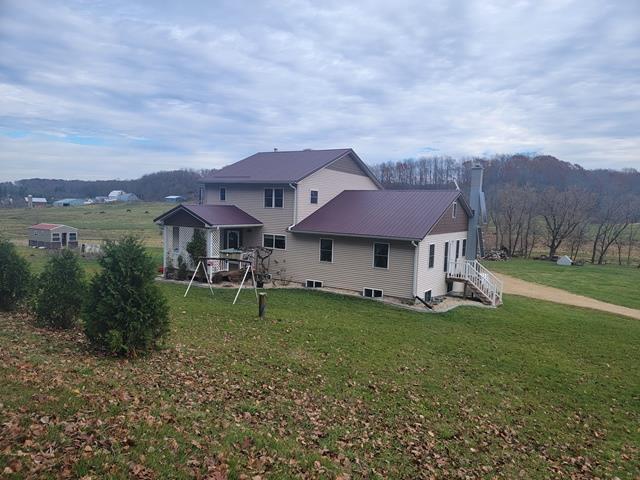 rear view of house featuring a lawn