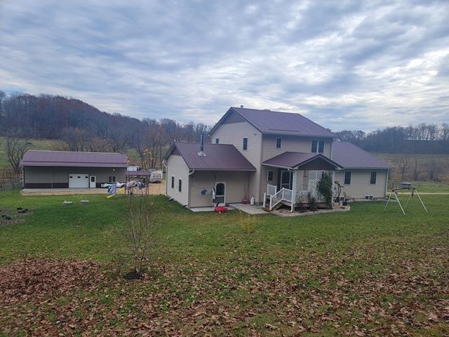 rear view of property featuring an outdoor structure and a yard