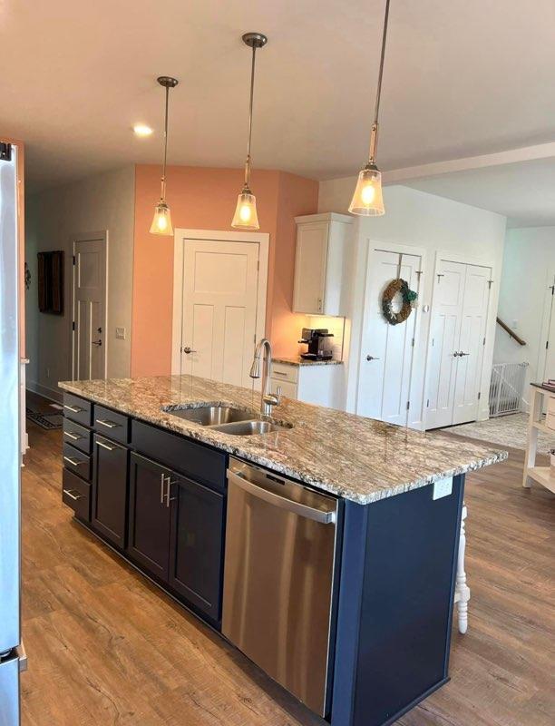 kitchen with dishwasher, white cabinetry, sink, and decorative light fixtures