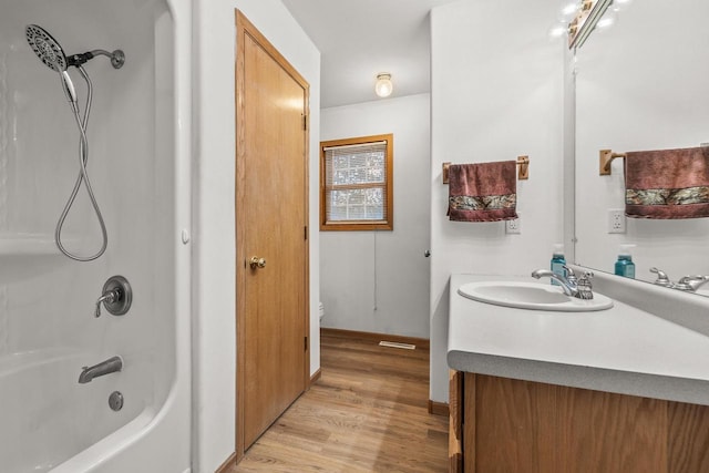 full bathroom with shower / bathing tub combination, hardwood / wood-style floors, vanity, and toilet