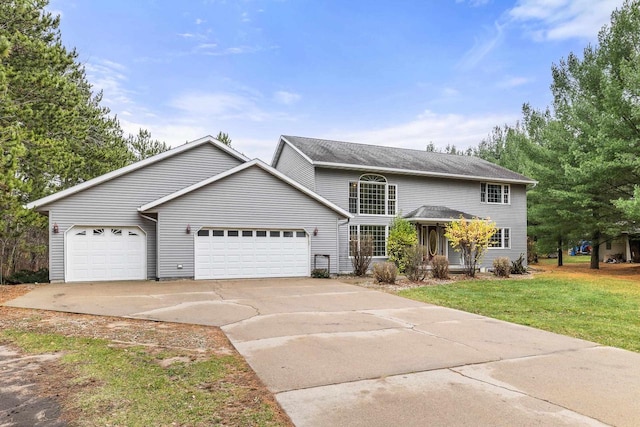 view of property featuring a garage and a front lawn