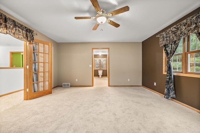 carpeted spare room featuring ceiling fan