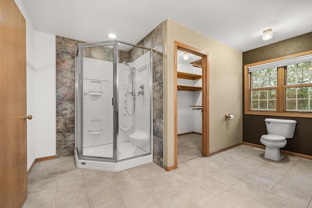 bathroom featuring tile patterned floors, a shower with shower door, and toilet