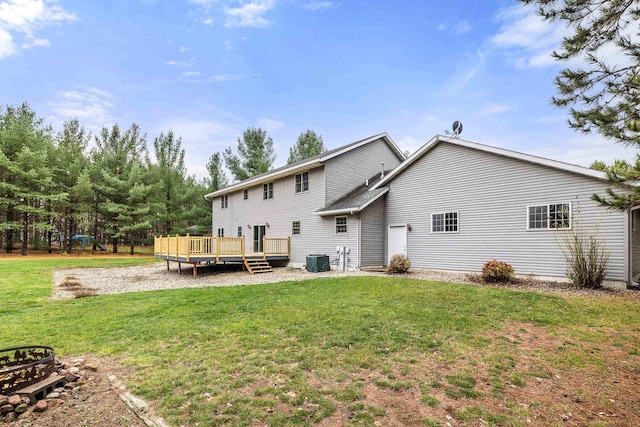 back of house with central air condition unit, a lawn, and a wooden deck