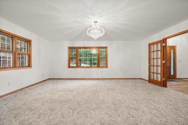 unfurnished room with light carpet and a notable chandelier