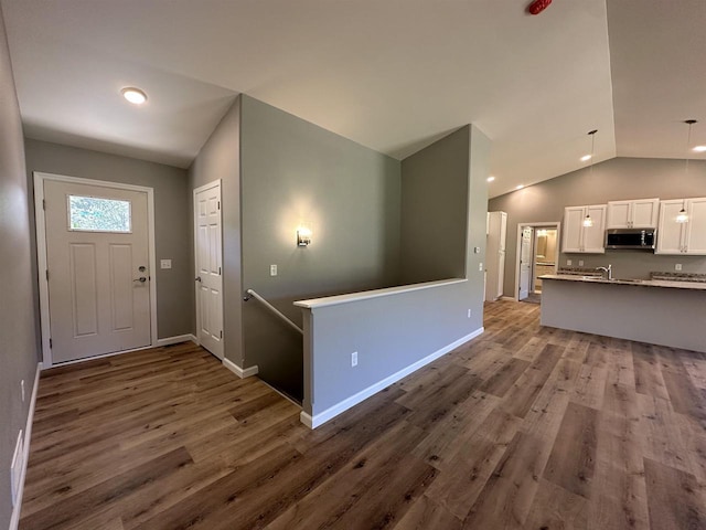 foyer featuring hardwood / wood-style flooring, lofted ceiling, and sink