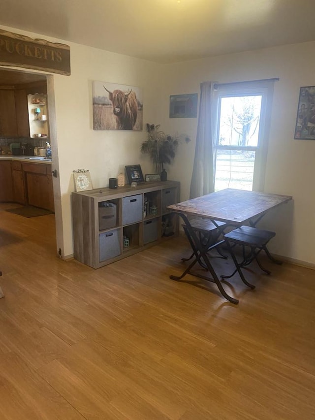 dining area with light wood-type flooring and sink