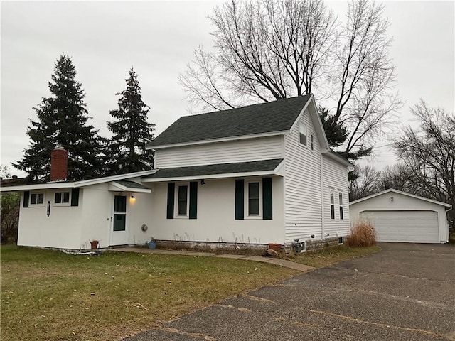 view of front of property with a garage, an outdoor structure, and a front lawn