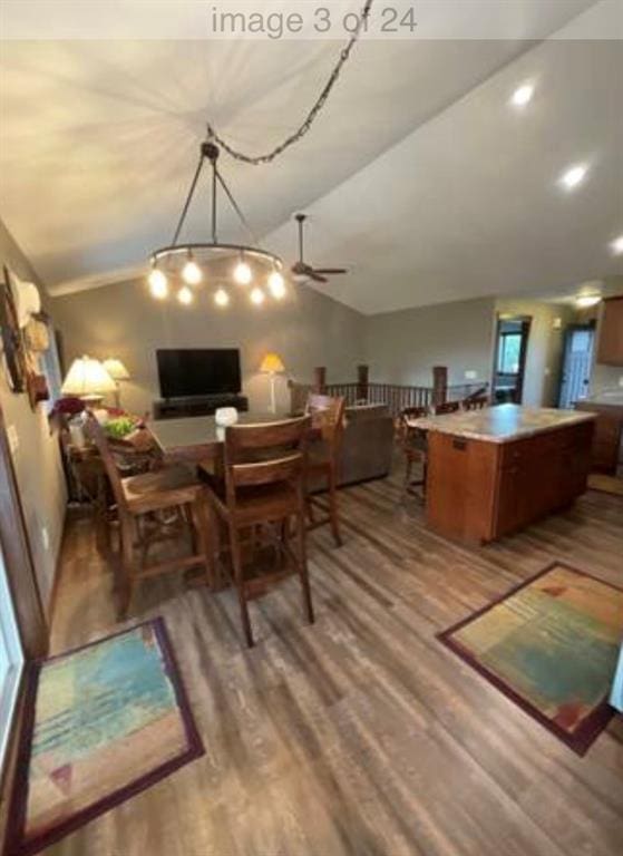 dining space with hardwood / wood-style floors, ceiling fan, and lofted ceiling