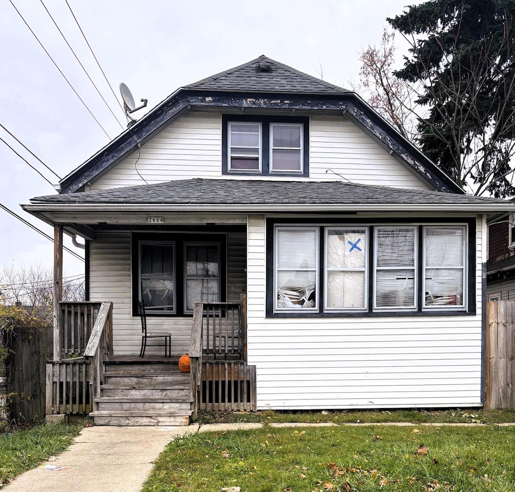 bungalow-style house featuring a porch and a front lawn