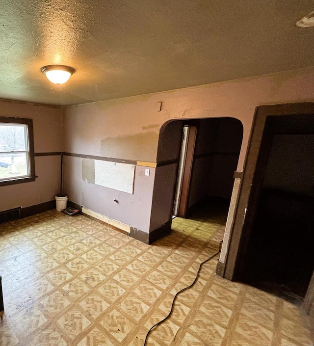 unfurnished room featuring a textured ceiling