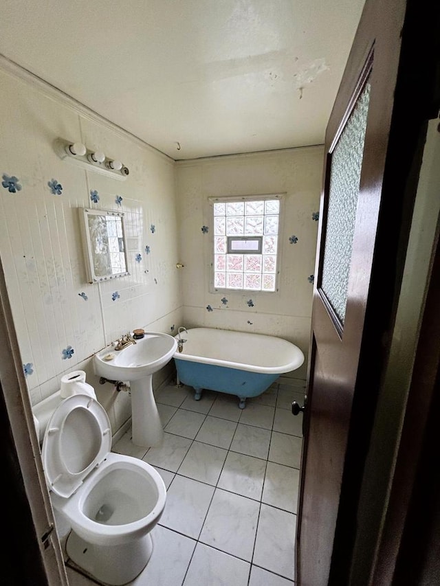 bathroom featuring tile patterned flooring, toilet, a bath, and tile walls