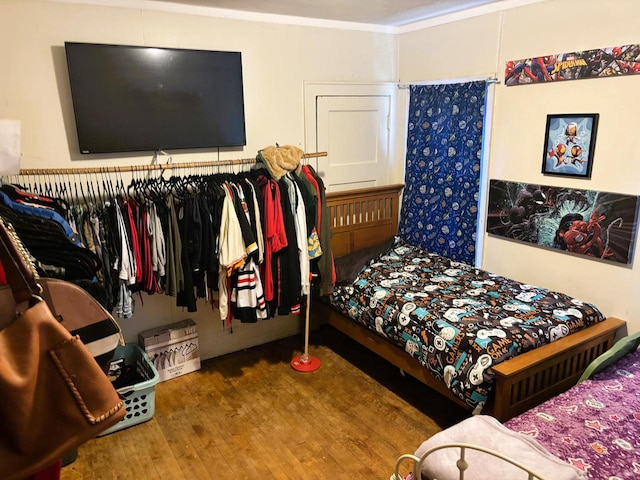 bedroom featuring wood-type flooring and crown molding