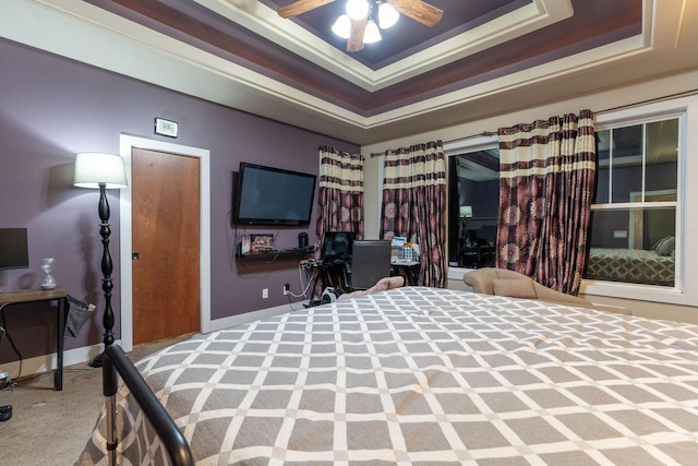 carpeted bedroom featuring ceiling fan, a raised ceiling, and crown molding