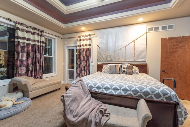 carpeted bedroom with a raised ceiling and ornamental molding